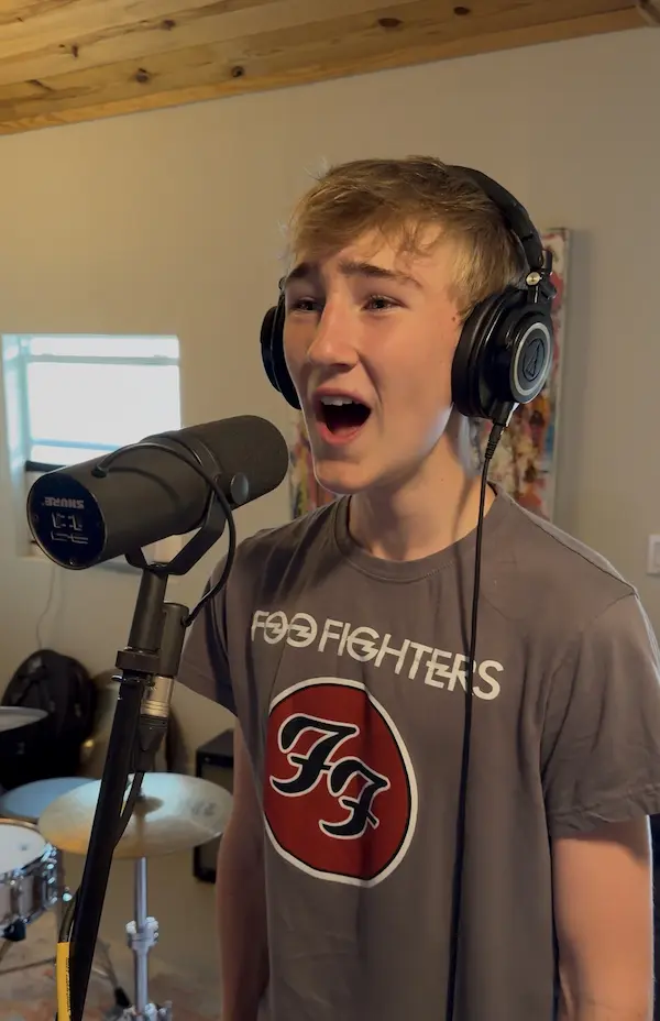 Student singing into a microphone in a studio