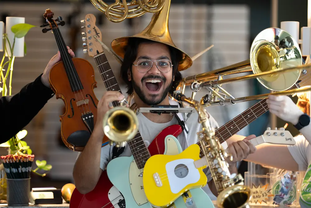 Instructor surrounded by multiple instruments, trying them all out