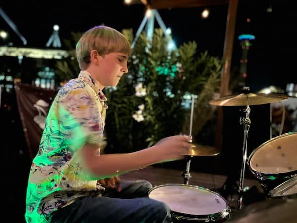 Band member playing drums at an evening show