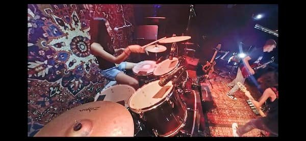 Drummer performing live, captured on video