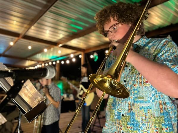 Band member playing trombone on the patio stage