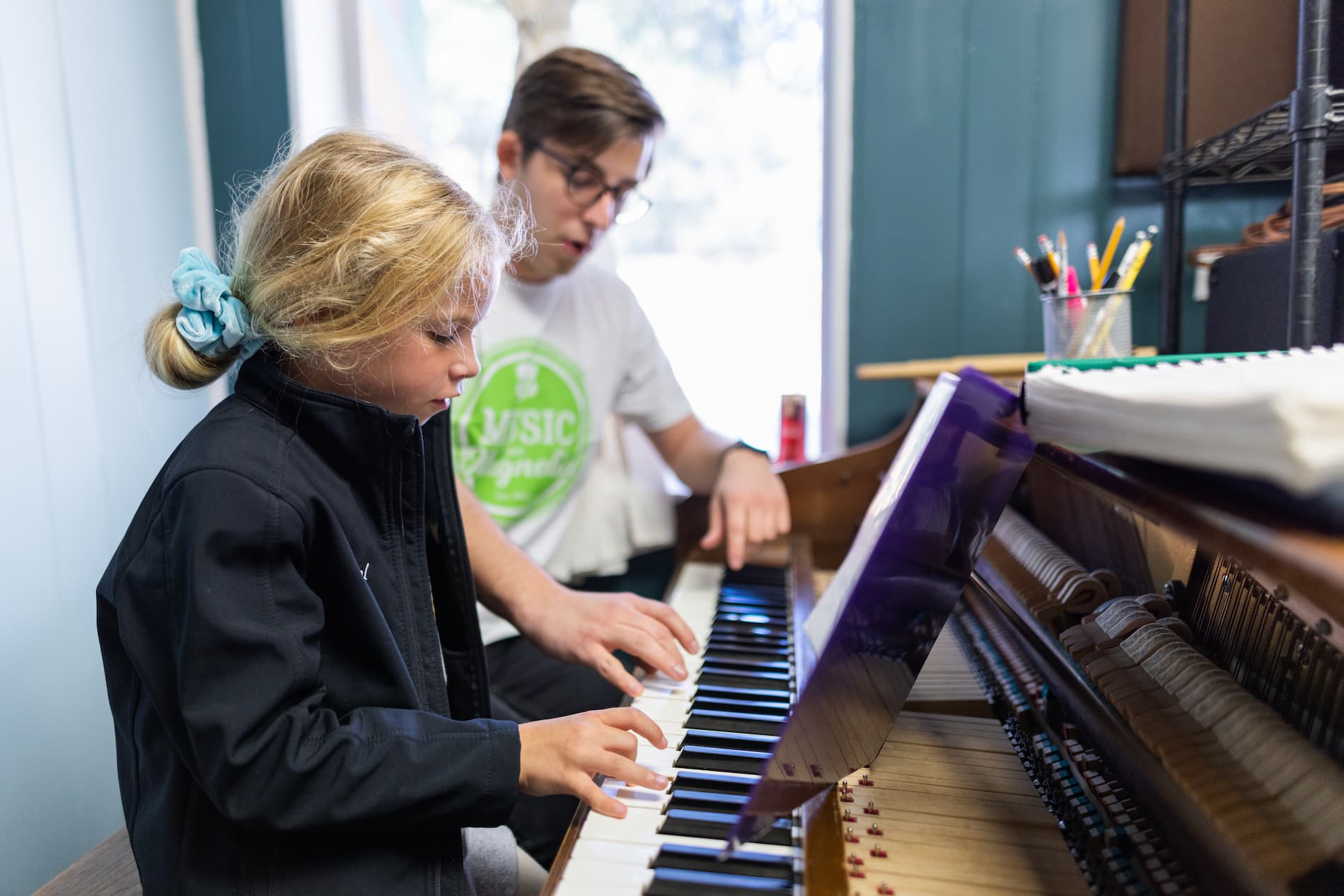 Instructor and student sitting at a piano lesson